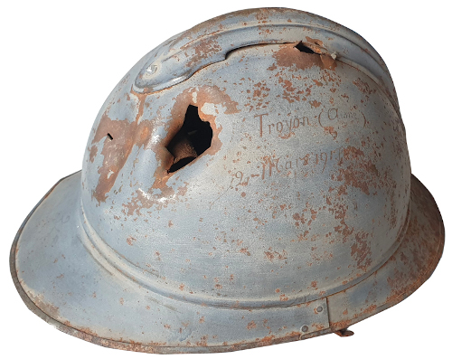 Casque Adrian modèle 15 percé par un éclat. Ce casque a sauvé la vie d’un soldat qui l’a conservé en souvenir de guerre après avoir écrit dessus « Troyon (Aine), 12 mars 1917 » - Coll. Eddy OZIOL