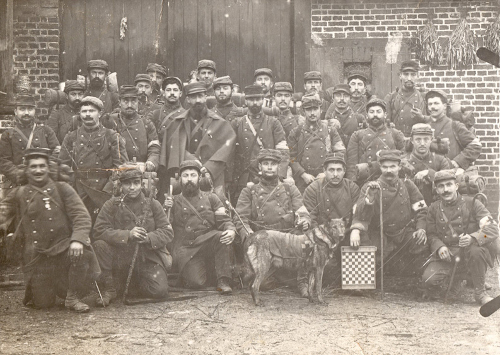 Groupe de brancardiers divisionnaires en tenue de campagne. Janvier 1915. Le chien sanitaire au premier rang est utilisé pour retrouver les blessés sur le champ de bataille – Coll. Eddy Oziol
